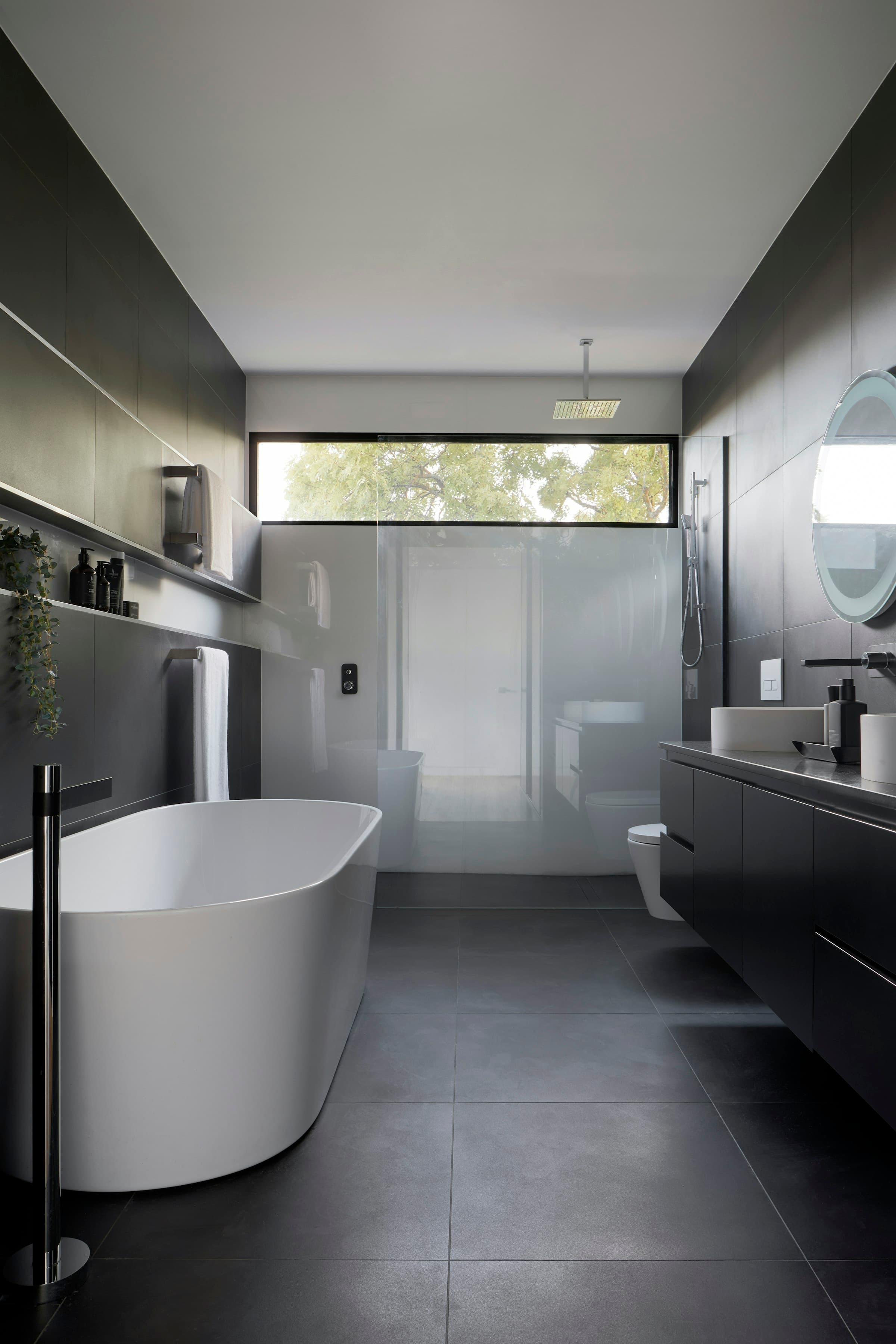 Calm bathroom with a freestanding tub, stone surfaces and soft lighting
