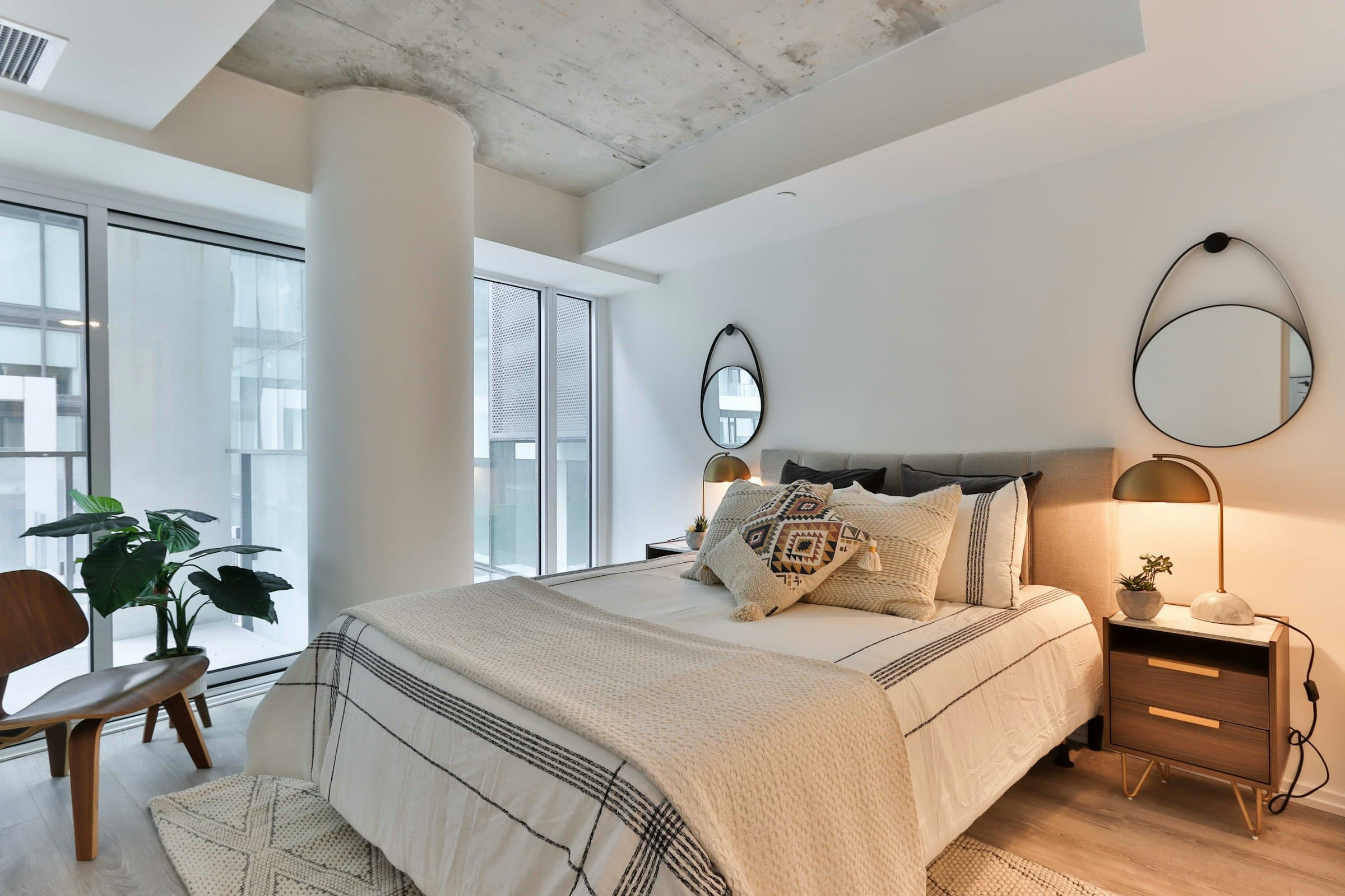 Luxurious bedroom with an upholstered bed, stone feature wall and soft ceiling lighting